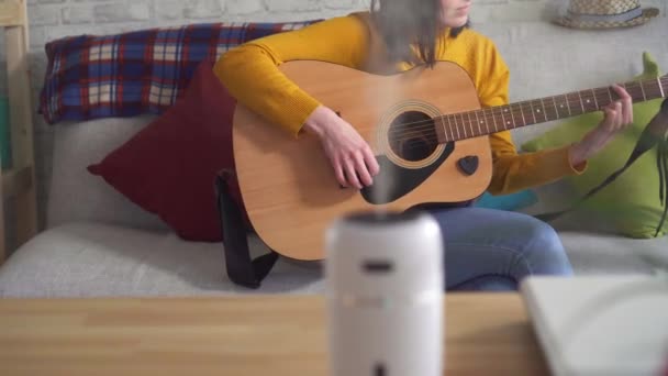 Jovem mulher melodias guitarra na mesa é umidificador ultra-sônico — Vídeo de Stock