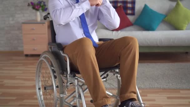 Gehandicapte man in een rolstoel jurken voor een spiegel — Stockvideo