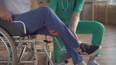 Yakın yukarı kız hemşire yardım bir özürlü kişi almak yukarı gelen bir tekerlekli sandalye