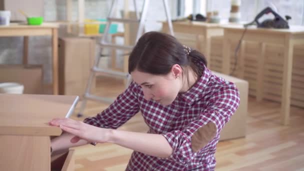 Yakın yukarı genç kadın başucu masasının montajında meşgul — Stok video