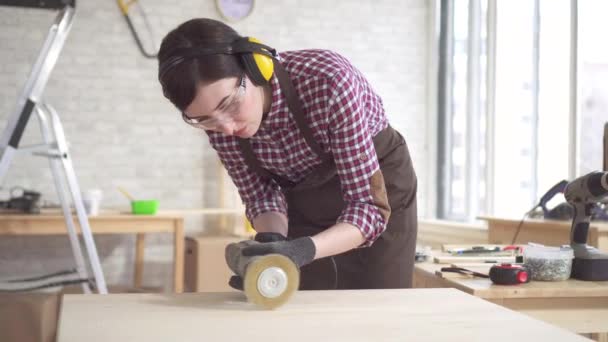 Close up professionele timmerman vrouw die belast is met het polijsten van de houten tafel — Stockvideo