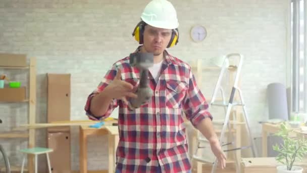 Портрет досвідченого професійного чоловіка з дрилем в руках і шоломом — стокове відео
