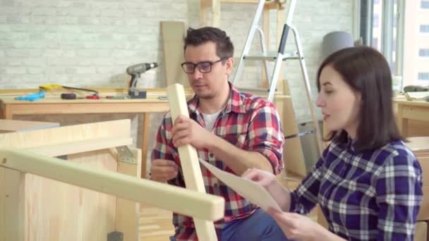 Close up jovem casal reúne uma mesa de cabeceira em um novo apartamento moderno — Vídeo de Stock