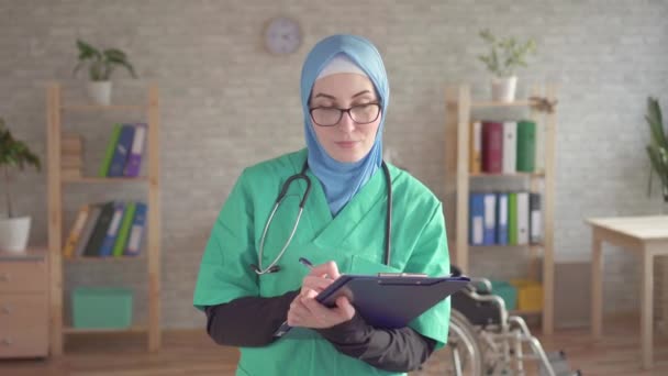 Portrait of muslim woman in hijab doctor smiling and looking at camera — Stock Video