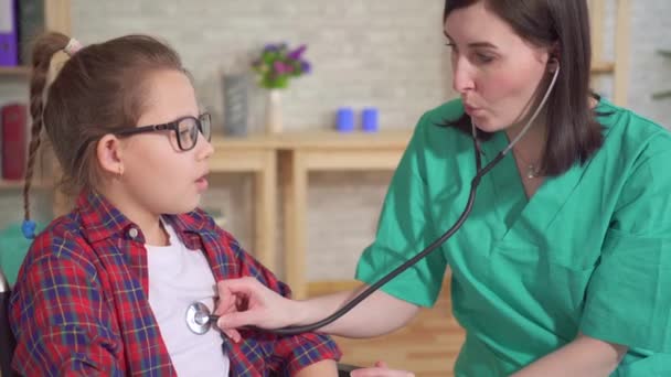 Terapeuta médico y el niño en silla de ruedas el uso de un estetoscopio — Vídeo de stock