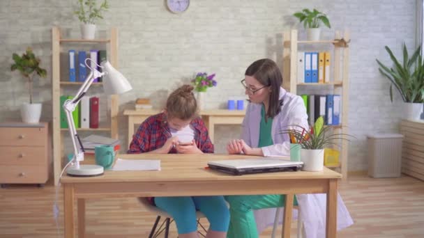 Läkare psykolog undervisar ett autistiskt barn att använda en smartphone — Stockvideo