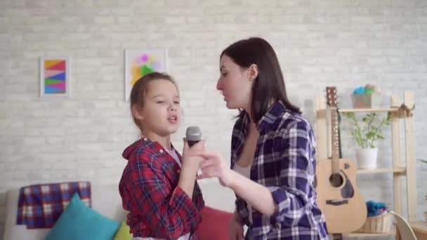 Κοντινό πάνω μαμά και κόρη συναισθηματικά τραγουδούν καραόκε στο σπίτι — Αρχείο Βίντεο