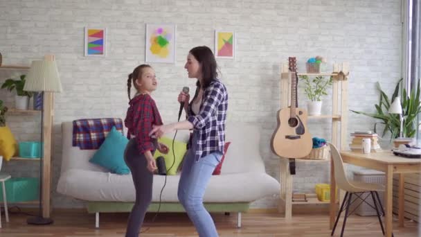 Mama i córka emocjonalnie śpiewają karaoke w domu — Wideo stockowe