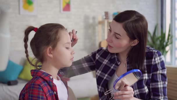 Мама учит дочь пользоваться косметикой. — стоковое видео