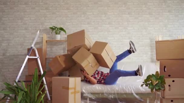 Mann mit großen Schachteln in der Hand fällt auf das Sofa — Stockvideo