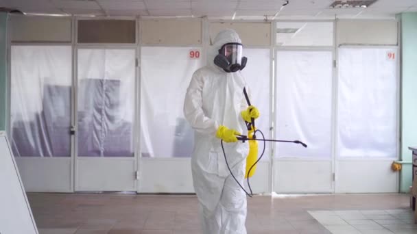 Exterminator in overalls and a protective mask with a sprayer — Stock Video