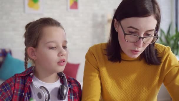 Close-up moeder helpen dochter doen huiswerk — Stockvideo