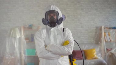 koruyucu bir maske ve beyaz bir tulum bir erkek bilim adamı portre, silah kamera için poz geçiş