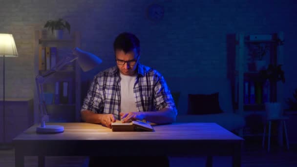 Man sits at a table and reads a prayer — Stock Video