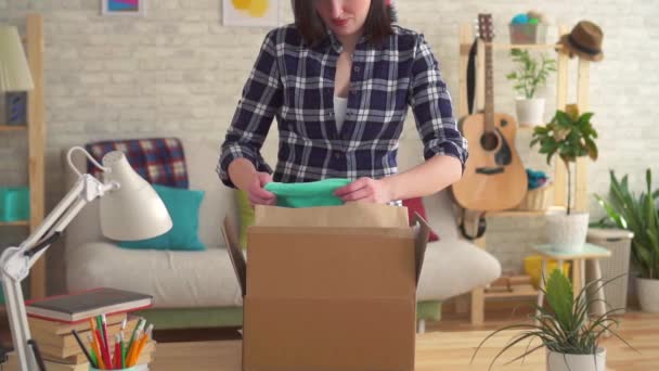 Young woman opens a box with a parcel slow mo — Stock Video