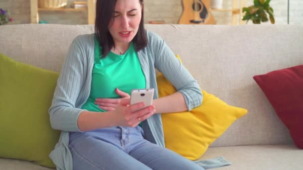 Portrait acute abdominal pain in a woman using a smartphone — Stock Video