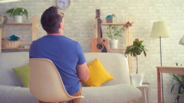 Adam bir sandalye üzerinde oturan bir pompa ile bir futbol topu sallar