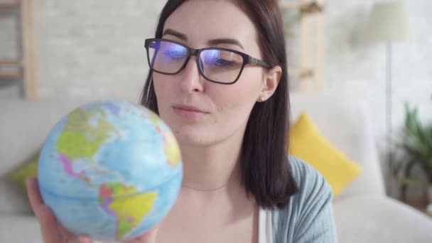 Close-up jonge vrouw bestudeert de Globe, holding it — Stockvideo