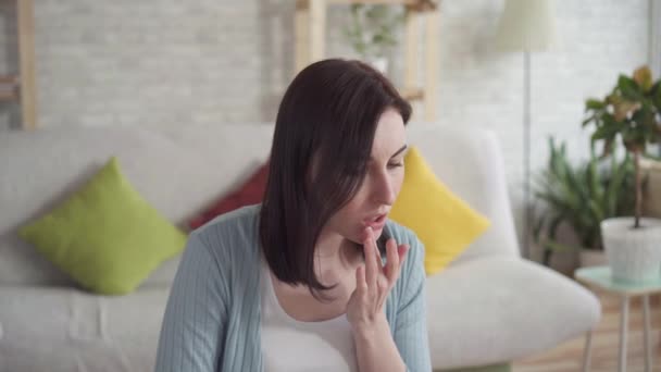 Κοντά σε μια νεαρή γυναίκα επιχρίσματα σκασμένα χείλη επούλωση βάλσαμο κάθεται — Αρχείο Βίντεο