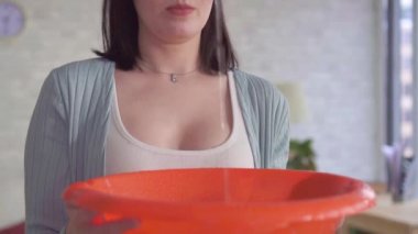 Bir kadın bir kova kullanarak yakın yukarı tavan yavaş Mo su damlaları yakalar