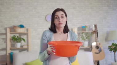 Şaşkın genç kadın tavana su damlaları yakalar ve kamera yavaş Mo bakıyor
