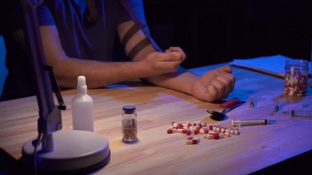 Close up homme ADDICT dans une pièce sombre à la table pénètre dans les médicaments — Video