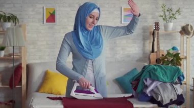 Tesettür ütülenmiş keten evde neşeli Müslüman Genç kadın