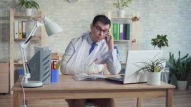 Telefonda konuşan kırık bir kol ile adam ofis çalışanı