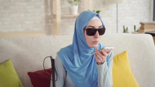 Porträtt av en blind muslimsk flicka hemma, Använd en smartphone — Stockvideo