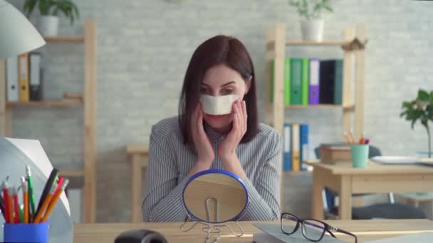 Mujer joven positiva después de la cirugía plástica en su cara mirando en el espejo — Vídeo de stock