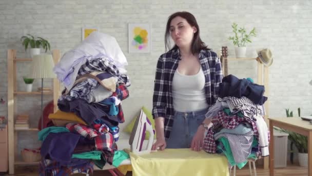 Trött ung kvinna hemmafru strykjärn linne inomhus — Stockvideo