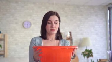 Portre karışık genç kadın tavandan su damlaları yakalar