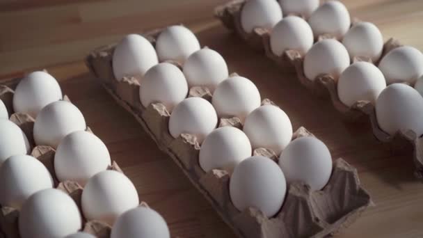 Pocos huevos en una caja de cartón sobre la mesa . — Vídeo de stock