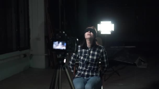 Пов'язана молода жінка в заручниках з зав'язаними очима сидить перед об'єктивом камери — стокове відео