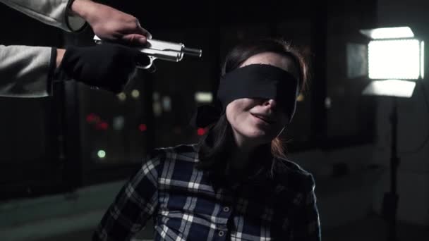 罪犯用枪指着被蒙住眼睛的绑住女人的头 — 图库视频影像