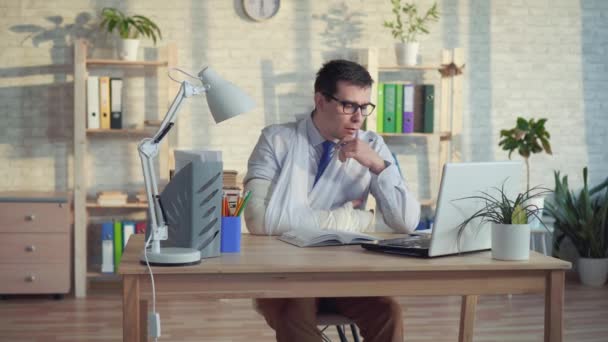 Man office worker wearing glasses with a broken arm — Stock Video