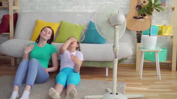 Anya és lánya mellett a ventilátor szenved, meleg időjárás — Stock videók