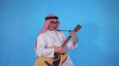 Akustik gitarı olan Arap adam