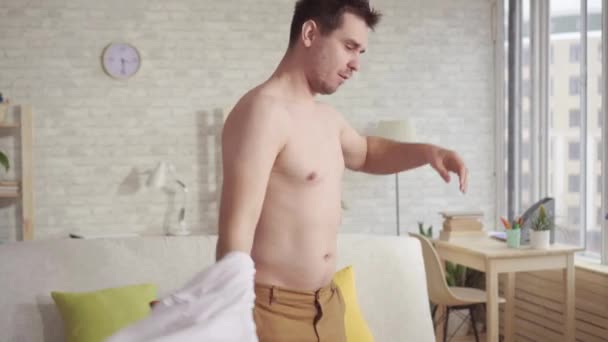 Young man looking in the mirror examines his body. — Stock Video