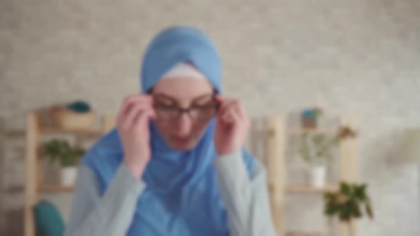 Wanita muslim muda dalam jilbab dengan penglihatan yang buruk mengenakan kacamata untuk penglihatan dan melihat-lihat — Stok Video