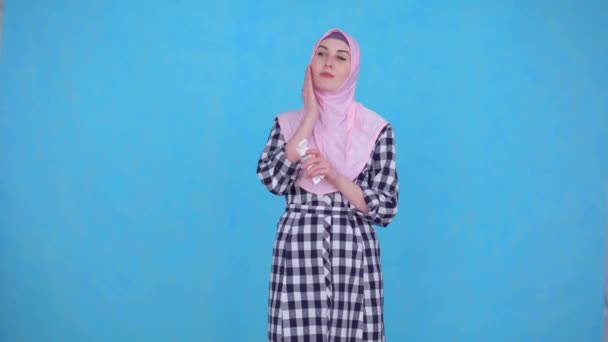 Молода мусульманка використовує крем для обличчя — стокове відео