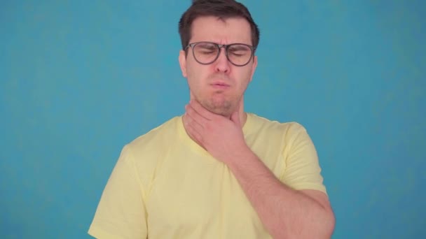 Мужчина среднего возраста в очках и футболках проблемы с больным горлом, использует спрей для лечения горла — стоковое видео