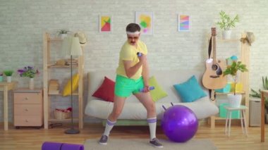 80'lerden bir bıyık ile komik genç adam evde dambıl ile meşgul