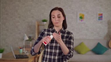 Genç bir kadın yüzündeki yanıktan dolayı yara izine krem sürer.