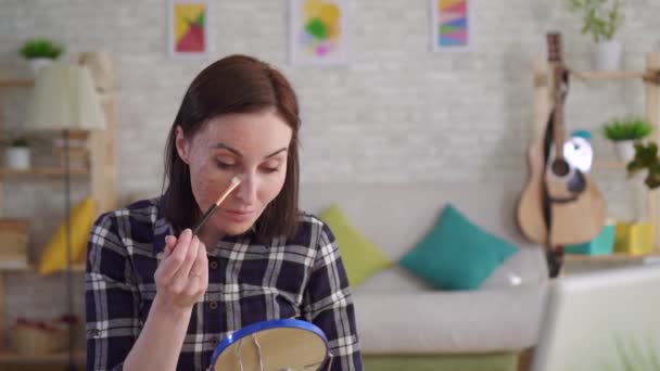 Junge Frau mit Narbe im Gesicht macht das Make-up — Stockvideo