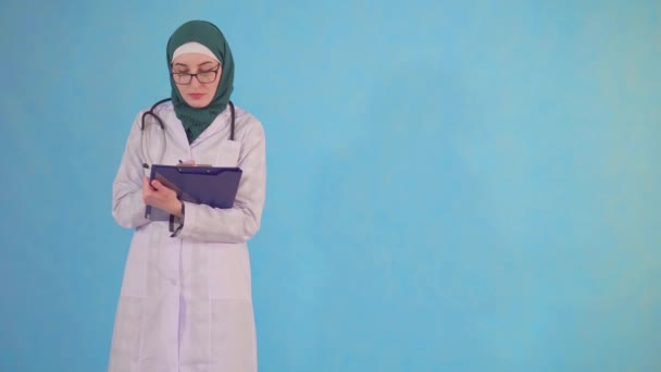 Portret van een jonge moslim arts die naar de camera kijkt — Stockvideo