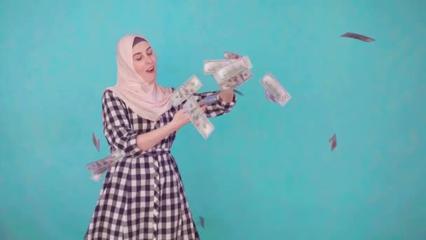 Genç Müslüman kadın kameraya bakıp gülümsüyor ve para saçıyor. — Stok video