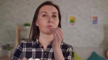 Yakın genç kadın yüzünde bir yanık bir yara izi krem koyar