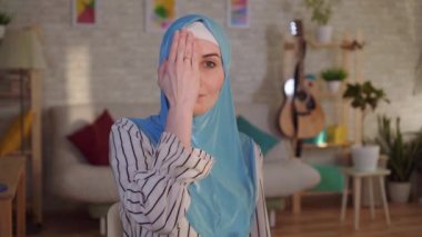 Yüzünde yanık izi olan tesettürlü genç bir Arap kadın.