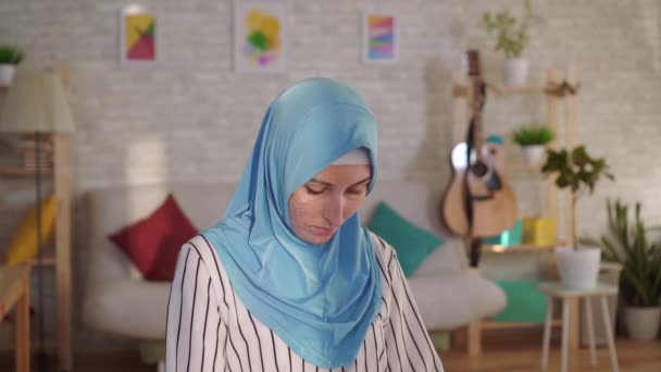Ung muslimsk kvinna i hijab med ett brännärr i ansiktet tittar på kameran — Stockvideo